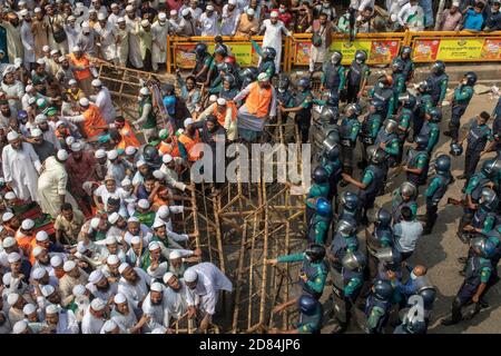 La police utilise des barrières pour arrêter les militants et les partisans de l'Islami Andoloon Bangladesh pendant la marche de protestation.l'Islami Andoloon, l'un des plus grands partis islamistes du Bangladesh, Organiser une marche de protestation appelant au boycott des produits français et dénonçant le président français Emmanuel Macron pour ses remarques « ne pas abandonner les dessins animés représentant le prophète Mahomet ». Les remarques de Macron ont été faites en réponse à la décapitation d'un professeur, Samuel Paty, devant son école dans une banlieue à Paris plus tôt ce mois-ci, après avoir montré des dessins animés du prophète Mahomet pendant une classe qu'il dirigeait sur la liberté d'expression. Banque D'Images