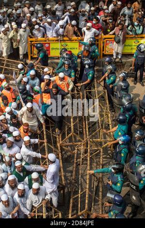 La police utilise des barrières pour arrêter les militants et les partisans de l'Islami Andoloon Bangladesh pendant la marche de protestation.l'Islami Andoloon, l'un des plus grands partis islamistes du Bangladesh, Organiser une marche de protestation appelant au boycott des produits français et dénonçant le président français Emmanuel Macron pour ses remarques « ne pas abandonner les dessins animés représentant le prophète Mahomet ». Les remarques de Macron ont été faites en réponse à la décapitation d'un professeur, Samuel Paty, devant son école dans une banlieue à Paris plus tôt ce mois-ci, après avoir montré des dessins animés du prophète Mahomet pendant une classe qu'il dirigeait sur la liberté d'expression. Banque D'Images