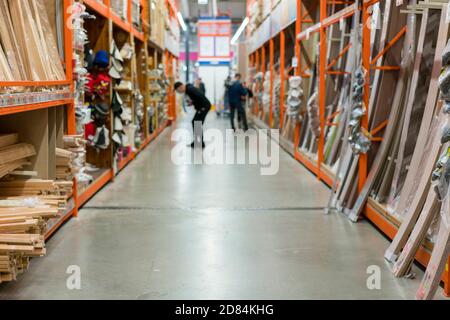 l'homme dans un masque médical de protection dans un magasin de quincaillerie choisit des planches. l'homme est protégé du coronovirus Banque D'Images