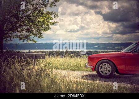 Voiture classique rouge garée avec vue Ammersee Banque D'Images