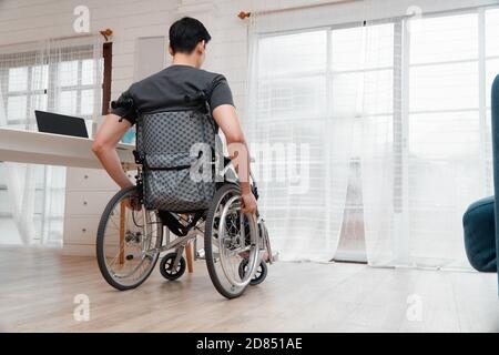 Un homme asiatique handicapé assis dans un fauteuil roulant est stressé et déçu après avoir eu un accident de voiture, le concept de négligence et les effets de drun Banque D'Images