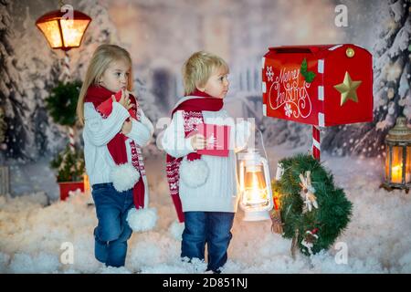 Mignons enfants blonds, garçons et filles, frères et sœurs, poster la lettre de Noël au Père Noël, jour d'hiver enneigé Banque D'Images