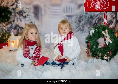 Mignons enfants blonds, garçons et filles, frères et sœurs, poster la lettre de Noël au Père Noël, jour d'hiver enneigé Banque D'Images