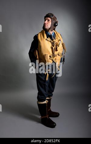 La Seconde Guerre mondiale, pilote de chasse de la RAF Bomber / membre de l'équipage, se tenant contre un arrière-plan gris studio. Banque D'Images