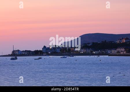 Vue sur la rivière Conwy en direction de l'estuaire de Conwy avec la ville de Deganwy au loin à Sunset, au nord du pays de Galles, Royaume-Uni. Banque D'Images