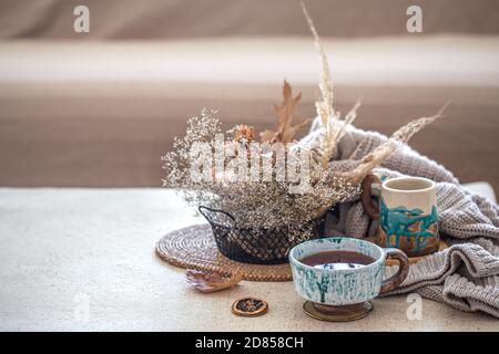 Maison confortable encore la vie avec une belle tasse de thé en céramique sur la table. Objets décoratifs à l'intérieur. Banque D'Images