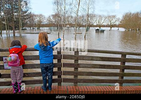 Les enfants regardent le terrain de sport inondé de Tonbridge, dans le Kent, au Royaume-Uni, à la suite des inondations de la rivière Medway voisine Banque D'Images