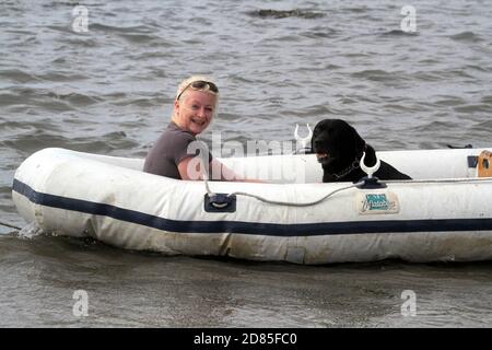 Maidens, Ayrshire, Écosse, Royaume-Uni. Un jeu en famille dans la mer avec un canot en caoutchouc parents adulte tenant avec l'enfant portant un gilet de sauvetage Banque D'Images