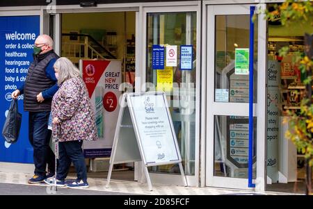 Dundee, Tayside, Écosse, Royaume-Uni. 27 octobre 2020. Port du masque Covid-19 : le port de masques protecteurs dans le centre-ville de Dundee est désormais obligatoire dans des endroits tels que les magasins et les rencontres lors des nouvelles restrictions de verrouillage du 3e Teir Covid-19. Les acheteurs portant des masques de visage en dehors du magasin Boots The Chemist et des panneaux demandant aux gens de magasiner en toute sécurité et de porter des masques de visage. Crédit : Dundee Photographics/Alamy Live News Banque D'Images