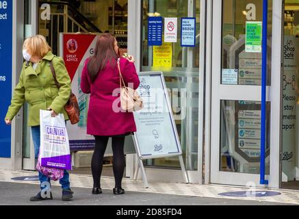 Dundee, Tayside, Écosse, Royaume-Uni. 27 octobre 2020. Port du masque Covid-19 : le port de masques protecteurs dans le centre-ville de Dundee est désormais obligatoire dans des endroits tels que les magasins et les rencontres lors des nouvelles restrictions de verrouillage du 3e Teir Covid-19. Les acheteurs portant des masques de visage en dehors du magasin Boots The Chemist et des panneaux demandant aux gens de magasiner en toute sécurité et de porter des masques de visage. Crédit : Dundee Photographics/Alamy Live News Banque D'Images