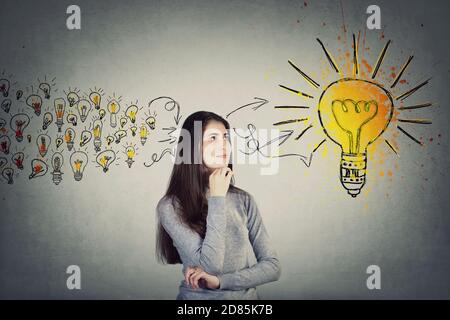 Une jeune fille étudiante réfléchie, garde la main sous le menton, recherchant une pensée positive pour une solution. Jeune femme ingénieuse adolescente rassemblant de nouvelles idées dans un Banque D'Images