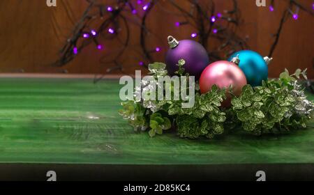 Gros plan de boules de Noël sur des branches décoratives avec un fond en bois et des lumières non focalisées en arrière-plan. Bannière pour Noël et le nouvel an. Banque D'Images