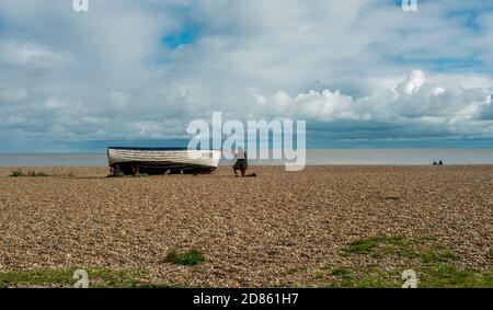 Homme en bateau de pêche sur la plage, Southwold, Norfolk, Royaume-Uni Banque D'Images