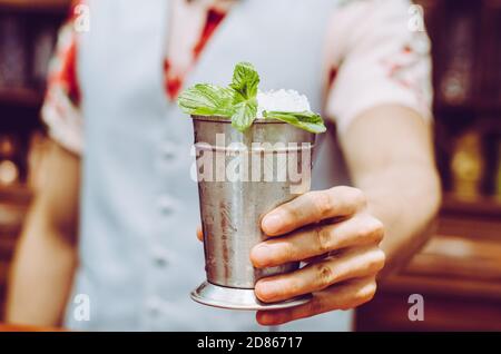 Barman préparant un délicieux cocktail de julep à la menthe à la table Banque D'Images