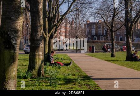 Londres, Royaume-Uni - 24 février 2019 : les gens s'assoient et se détendent sur une pelouse verte dans un parc. Après-midi d'été dans le parc. Aucune mise au point, en particulier. Banque D'Images