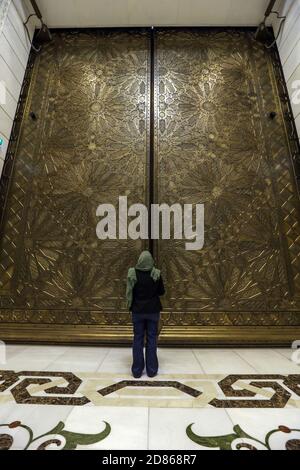 27 octobre 2020, Algérie, Alger : une femme regarde une porte de la Grande Mosquée d'Alger, également connue sous le nom de Djamaa el Djazair. La Grande Mosquée d'Alger a été conçue par la société d'architecture allemande KSP Juergen Engel Architekten et les ingénieurs de Krebs und Kiefer International et construite par la China State Construction Engineering Corporation (CSCEC). La mosquée, qui est considérée comme l'une des plus grandes mosquées du monde et abrite le plus haut minaret du monde, s'ouvrira jeudi à la prière à l'occasion d'Al-Mouled Al-Nabawy et sera officiellement inaugurée le premier de Novemb Banque D'Images