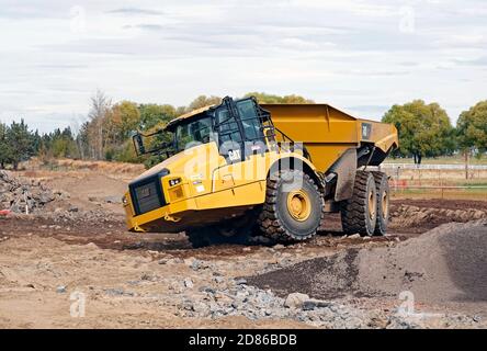 Un grand camion-benne de terrassement sur un chantier de construction à Bend, Oregon, déplace les blocs vers un broyeur de roche pour fabriquer du gravier. Le site de construction est pour Banque D'Images