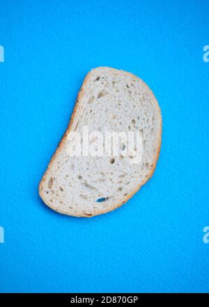 Trois tranches de pain de blé blanc sur fond bleu Banque D'Images