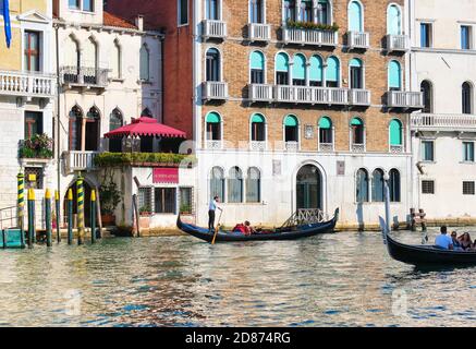 Les gondoliers emmenant les touristes sur sa gondole le long du Grand Canal. Les touristes reviennent à Venise, mais beaucoup moins que ces dernières années. Banque D'Images