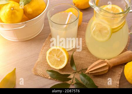 Limonade maison sur la table de cuisine avec panier rempli de citrons. Vue en hauteur du dessus. Composition horizontale. Banque D'Images