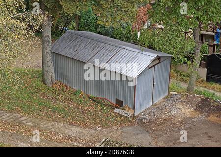 Structure de garage en métal caché dans les bois Banque D'Images