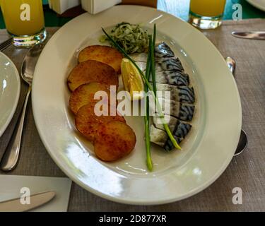 Maquereau salé avec pommes de terre frites, oignons et citron Banque D'Images