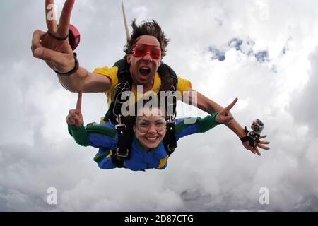 Parachutisme bonheur en tandem par temps nuageux Banque D'Images