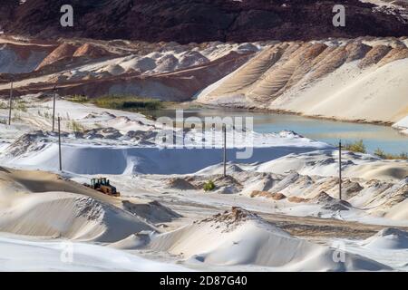 Extraction de sable avec pelle mécanique dans une carrière de quartz. Dunes de sable collines terrain creusant près du lac Banque D'Images