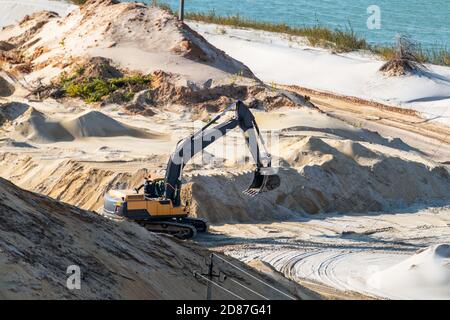 Extraction de sable avec pelle hydraulique à la carrière de quartz de près. Dunes de sable collines terrain creusant près du lac Banque D'Images