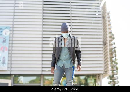 jeune homme africain marchant dans la ville Banque D'Images
