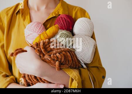 Rouleaux de cordes de coton dans la main de femme. Tricotage, crochetage, concept de passe-temps fait main Banque D'Images