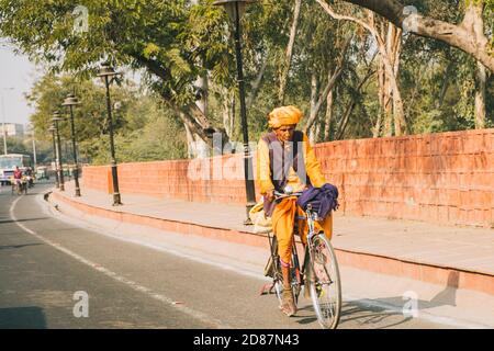 Vieil homme qui fait du vélo dans les rues d'Agra en passant par le fort d'Agra. Banque D'Images