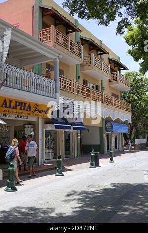 La vue du côté du bâtiment avec des boutiques au rez-de-chaussée et des personnes marchant dans les rues de St.Martin. Banque D'Images