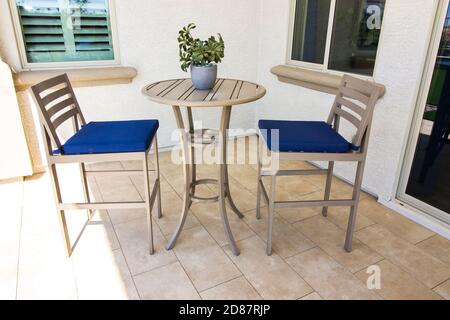 Patio arrière couvert avec grande table et deux chaises Coussins bleus Banque D'Images