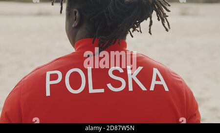 Vue arrière de l'homme noir afro-américain en chemise rouge. La Pologne écrit sur le dos. Photo de haute qualité Banque D'Images