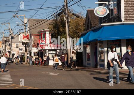 Les touristes marchent le long de commercial Street à Provincetown, Massachusetts. Certains portent des masques, d'autres pas. Banque D'Images