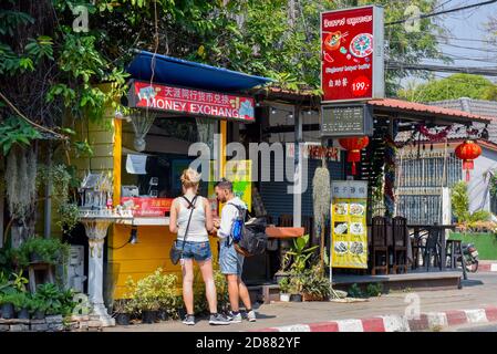 Jeunes touristes étrangers échangeant de l'argent, Chiang Mai, Thaïlande Banque D'Images