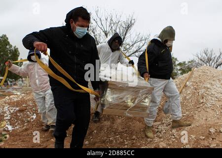 Ciudad Juarez, MEXIQUE. 27 octobre 2020. Les employés du cimetière enterrent les corps de personnes infectées par le COVID-19 à Ciudad Juarez, une colonne de fumée s'élève du crématoire du cimetière municipal de San Rafael. Les victimes de la COVID-19 sont enterrées dans une partie distincte du cimetière. Aujourd'hui, le Mexique a atteint un total de 900,000 cas et près de 90,000 décès dus à la COVID-19. Crédit : Corrie Boudreaux/Alay Live News Banque D'Images