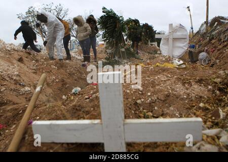 Ciudad Juarez, MEXIQUE. 27 octobre 2020. Les employés du cimetière enterrent les corps de personnes infectées par le COVID-19 à Ciudad Juarez, une colonne de fumée s'élève du crématoire du cimetière municipal de San Rafael. Les victimes de la COVID-19 sont enterrées dans une partie distincte du cimetière. Aujourd'hui, le Mexique a atteint un total de 900,000 cas et près de 90,000 décès dus à la COVID-19. Crédit : Corrie Boudreaux/Alay Live News Banque D'Images