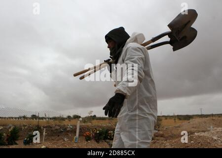 Ciudad Juarez, MEXIQUE. 27 octobre 2020. Les employés du cimetière enterrent les corps de personnes infectées par le COVID-19 à Ciudad Juarez, une colonne de fumée s'élève du crématoire du cimetière municipal de San Rafael. Les victimes de la COVID-19 sont enterrées dans une partie distincte du cimetière. Aujourd'hui, le Mexique a atteint un total de 900,000 cas et près de 90,000 décès dus à la COVID-19. Crédit : Corrie Boudreaux/Alay Live News Banque D'Images