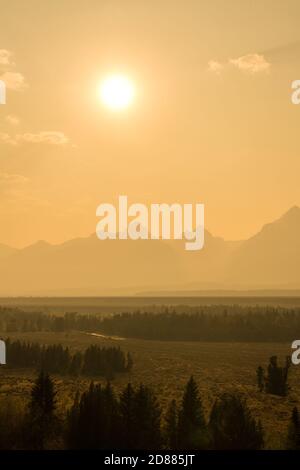 Un coucher de soleil brumeux sur la chaîne de montagnes de Teton. Parc national de Grand Teton, Wyoming, États-Unis. Banque D'Images