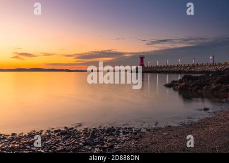 Coucher de soleil en bord de mer, phare sur brise-lames. Seosan-si, Chungcheongnam-do, République de Corée. Banque D'Images