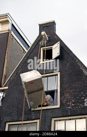 Une série de photos montre le levage de meubles à l'étage supérieur d'une maison de canal à Amsterdam, Hollande où le système de levage de poulie extérieure est utilisé. Banque D'Images