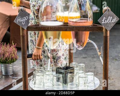 Vintage shabby chic vieilles bouteilles suspendues avec vin et jus de maracuja lors d'un mariage une fête. Banque D'Images