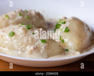 Cepelinai (didžkukuliai) servi dans des boulettes légères à base de pommes de terre râpées et glacées, farcies de viande hachée ou de fromage à caillé sec ou de champignons. Il h Banque D'Images