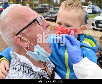 Bitterfeld Wolfen, Allemagne. 26 octobre 2020. Dans le centre de test de l'autorité sanitaire, district Bitterfeld- Wolfen, un père et son fils sont testés par le Dr. Norbert Braun et Tobias Fischer (r-l) de RettMedic. Le nombre de personnes testées est en augmentation dans le district, comme c'est le cas dans toute l'Allemagne. Credit: Waltraud Grubitzsch/zb/dpa/Alay Live News Banque D'Images