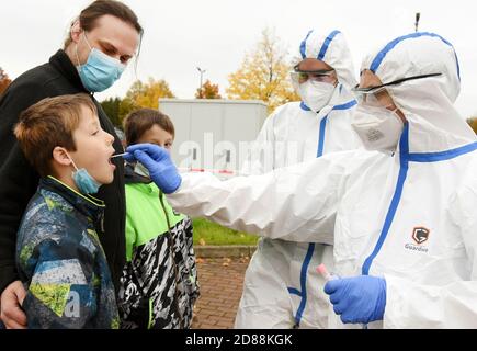 Bitterfeld Wolfen, Allemagne. 26 octobre 2020. Dans le centre de test de l'autorité sanitaire, district de Bitterfeld-Wolfen, un père avec ses enfants est testé par le Dr. Norbert Braun et Tobias Fischer (r-l) de RettMedic. Dans le district, comme dans le reste de l'Allemagne, le nombre de personnes testées augmente. Credit: Waltraud Grubitzsch/zb/dpa/Alay Live News Banque D'Images