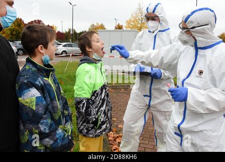 Bitterfeld Wolfen, Allemagne. 26 octobre 2020. Dans le centre de test de l'autorité sanitaire, district de Bitterfeld-Wolfen, un père avec ses enfants est testé par le Dr. Norbert Braun et Tobias Fischer (r-l) de RettMedic. Dans le district, comme dans le reste de l'Allemagne, le nombre de personnes testées augmente. Credit: Waltraud Grubitzsch/zb/dpa/Alay Live News Banque D'Images