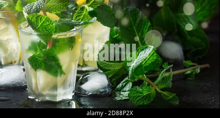 Cocktail alcoolisé, thé à la menthe avec rhum dans de petits verres avec glace dans un coeur en bois d'époque, foyer sélectif Banque D'Images