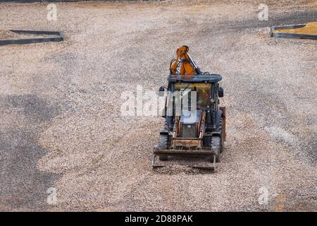 Russie, Kaluga - 27 OCTOBRE 2020 : tracteur avec godet de nivellement de gravier pour la construction de routes. Banque D'Images